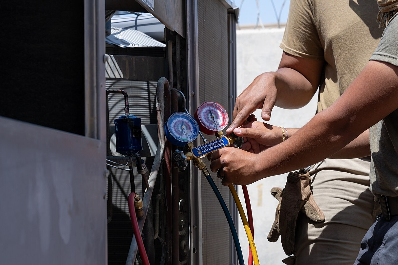 A technician inspecting an air-conditioning unit
